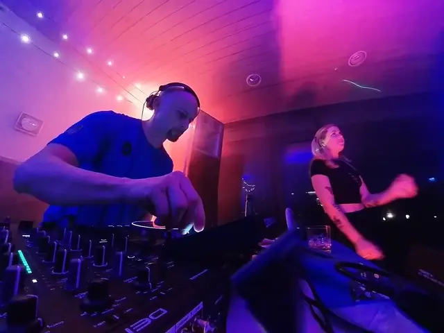 Behind the decks under blue and pink club lights